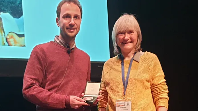 man being presented with a trophy