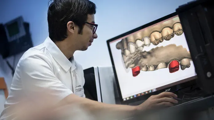 Researcher looking at image of teeth on computer