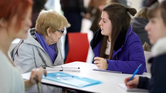 Social work student speaking to elderly person
