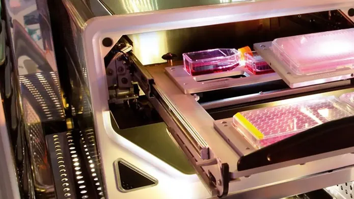 The inside of an instrument that analysis live cells showing trays of microplates