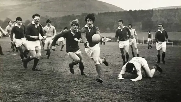 Black and white photo of students playing rugby