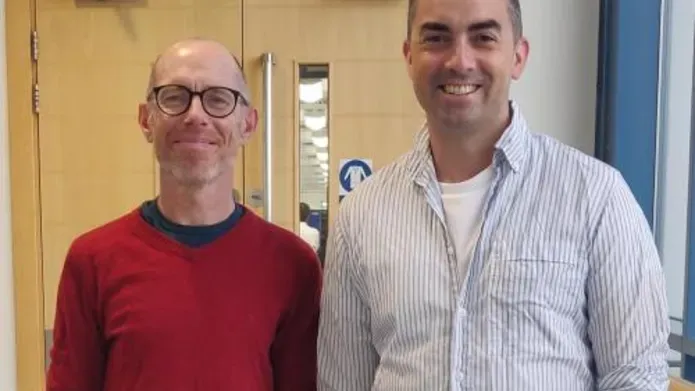 Dr Stephen Mathes and Dr David Millrine standing in front of an office door
