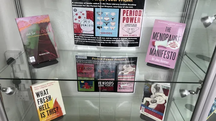 a glass shelf with a range of period related books on display