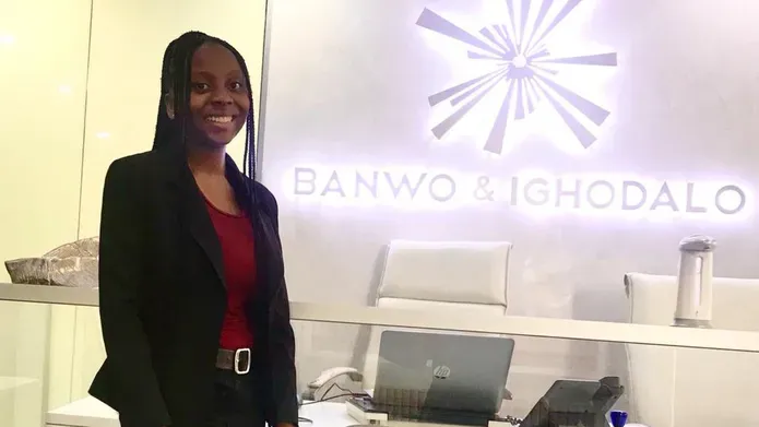 Abimbola Ibiwoye standing in front of an office sign for Banwo & Ighodalo