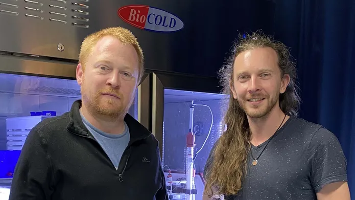 Dr David Murray and Dr Hannes Maib standing in front of a lab refrigerator
