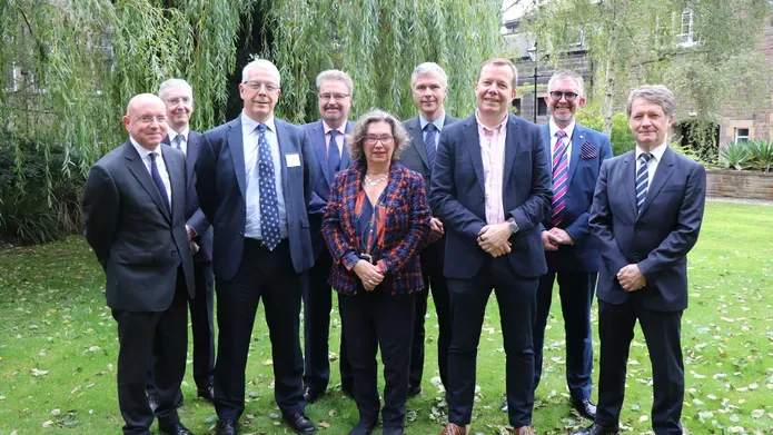 Attendees of the launch of the Dundee Dental Hospital and Research School gather in a garden space. Professor Jan Clarkson stands in the middle 