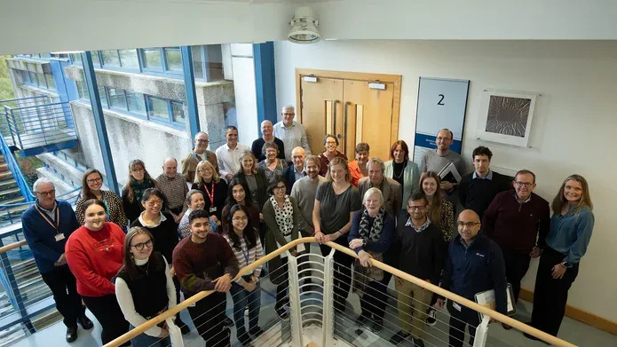 The Parkinson's research team standing at a balcony in the School if Life Sciences building.