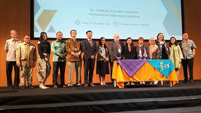 A group stood on stage in front of presentations slides