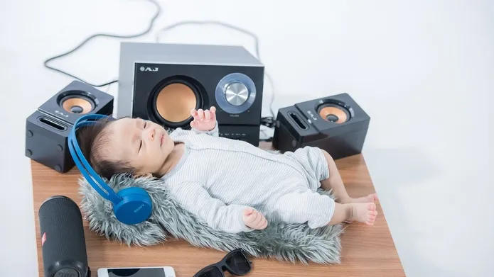 Baby lying back listening to music on headphones