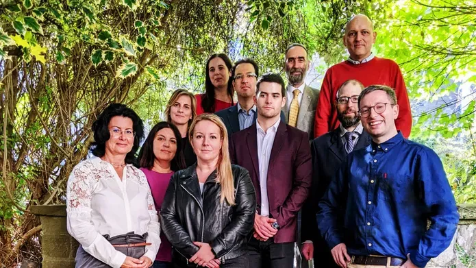 A group of people who took part of a visit to COI standing in a woodland area