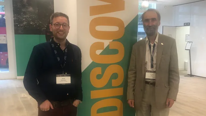 Dr Sean Whittaker and Prof Colin Reid standing in a lobby next to a column with the word Discovery