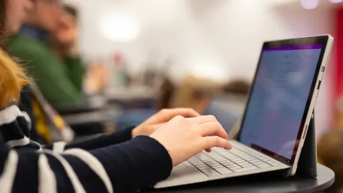 Student using a laptop in a lecture