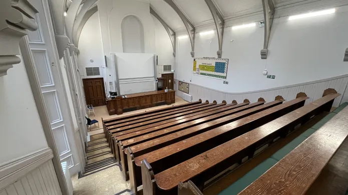 Carnelley Large Lecture Theatre a view from the top of the theatre showing rows of wooden benches and ornate ceiling