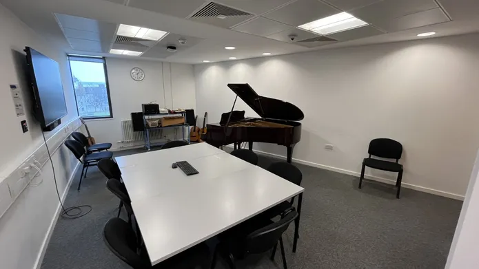 Dalhousie 1S11 - music room with a piano and tables set in a square with chairs
