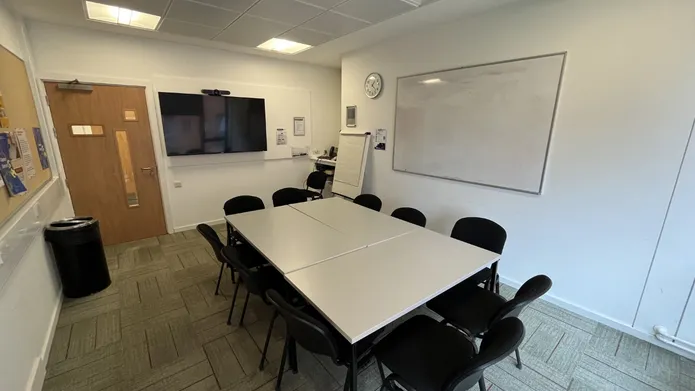 Dalhousie 2S01 - one table set up in an oblong shape with chairs. A white board and tv screen on the wall