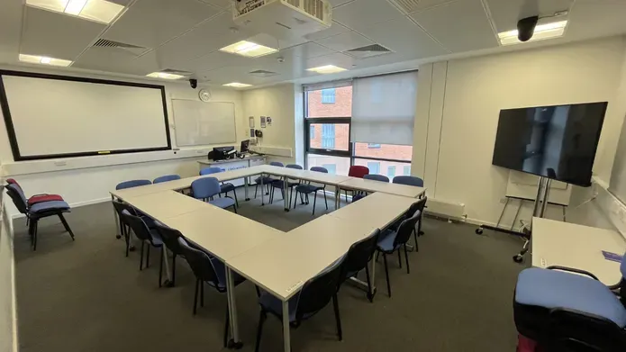 Dalhousie 2S02 - tables and chairs with a mobile tv screen and white screen at far wall