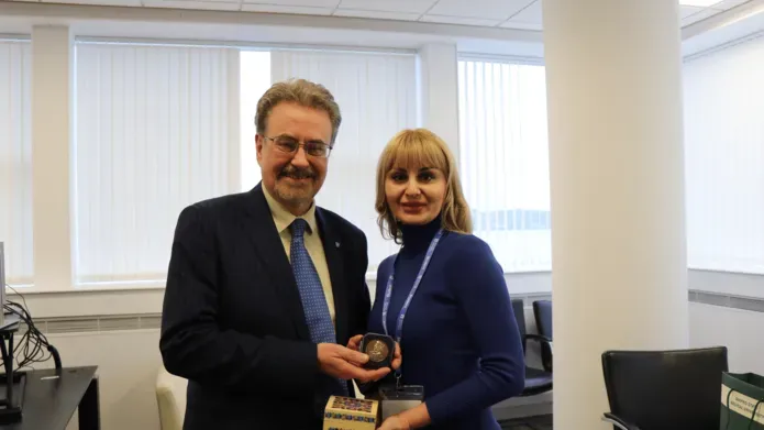 Professor Iain Gillespie and Professor Kamilla Mahrlamova standing side by side smiling in an office holding a brinze medal and a ornate box decorated with a traditional Ukrainian flower design