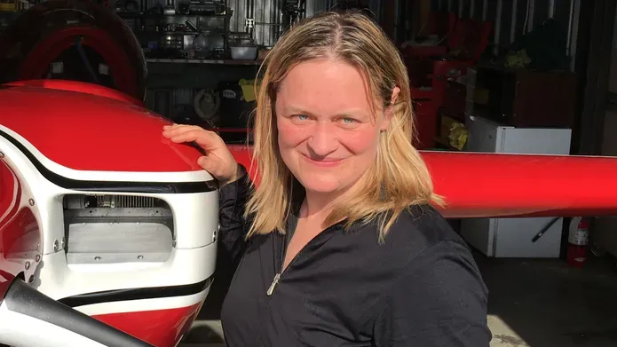Pic of Prof Iris Grunwald standing next to an airplane