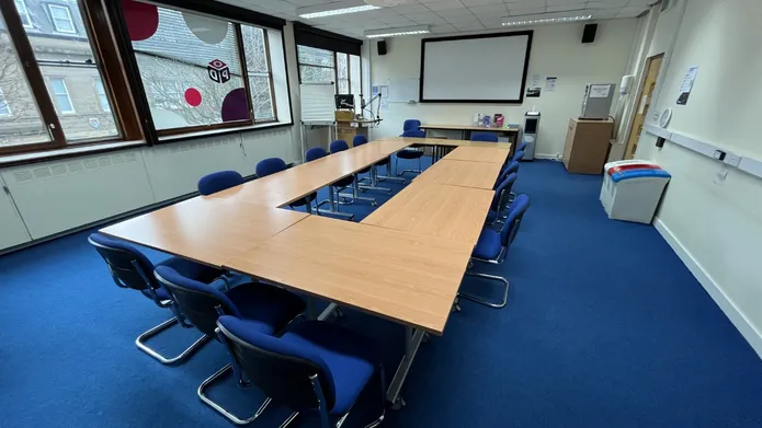 Tower T8 has a table set up in a boardroom style with a white screen at the front
