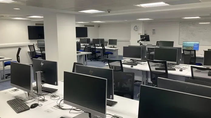 IT  Suite in the Tower Basement showing several rows of computer screens on white desks 