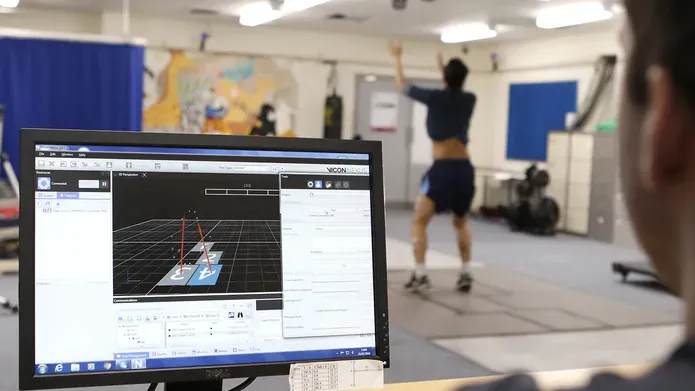 Desktop screen with analysis diagrams. In the background is a person doing exercise. 