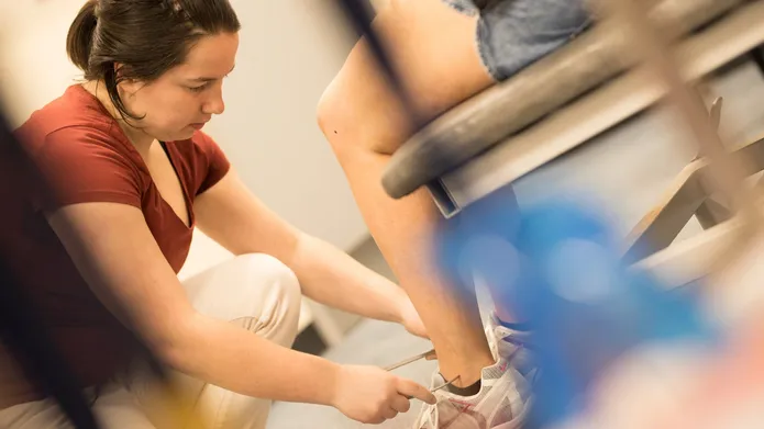 Lady measuring a foot for orthopaedic research. 