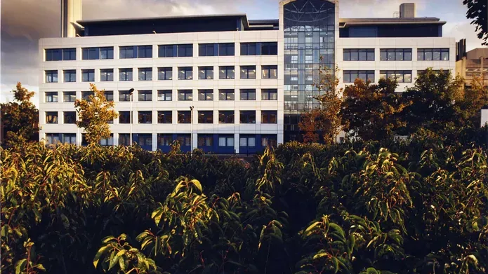 The Wellcome Trust building, with bushes in the foreground.