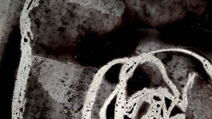 A segment of a drawing made with wax resist crayon and black ink, shows textural, sweeping white marks on a black washy background