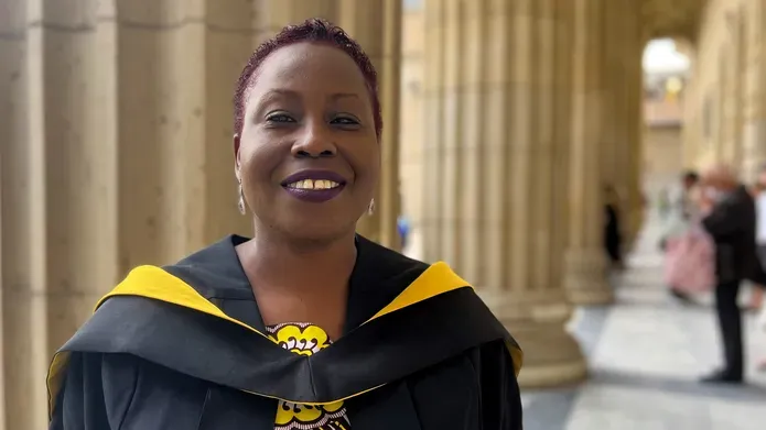 Ify Tony-Monye dressed in graduation robes outside Caird Hall