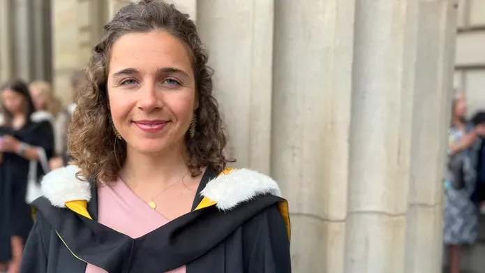 Maitane on graduatoin day outside caird hall wearing her graduation robe