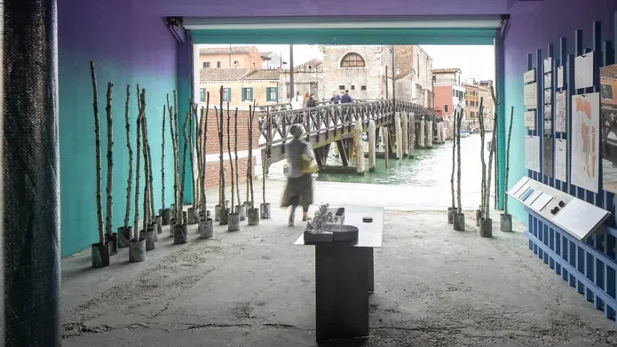 A figure is standing at the far end of a room with an open wall leading onto canals.