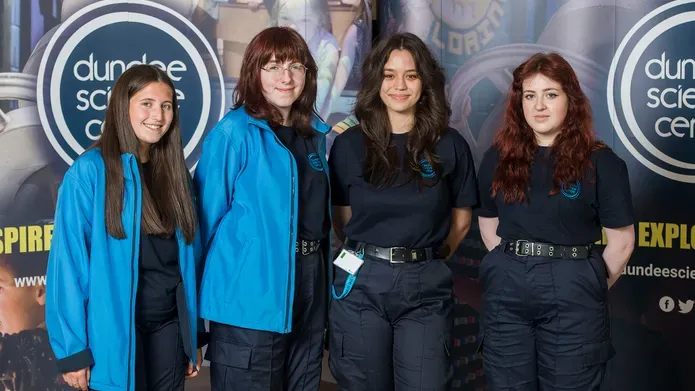 Four students standing in front of a Dundee Science Centre banner