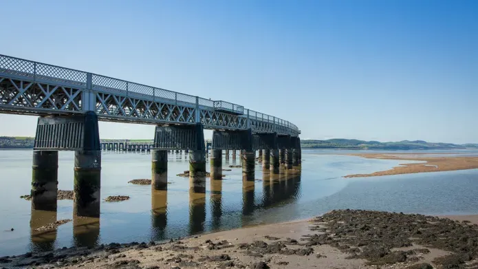 rail bridge stretching out across the river on a sunny day