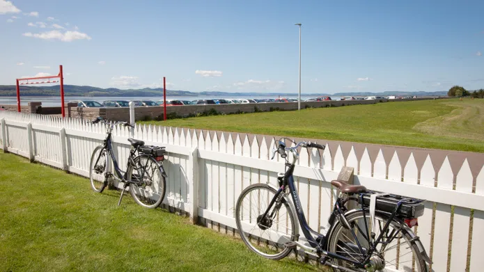 bikes alongside white fence looking out towards the river