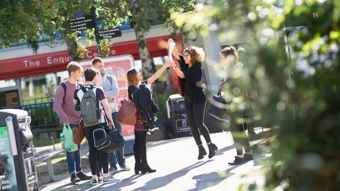 students outside of red 'enquiry centre' building