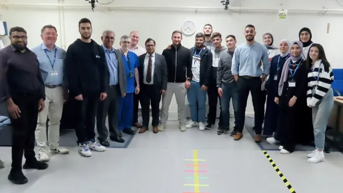 A group of summer school students standing in a room in the medical school.