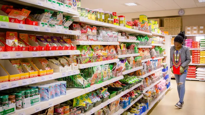 student looking along supermarket shelves
