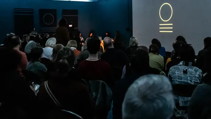 large audience seated listening to a panel discussion