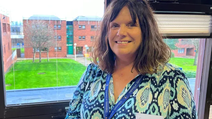 Suzanne Bell, standing in front of a window at Kirkcaldy campus