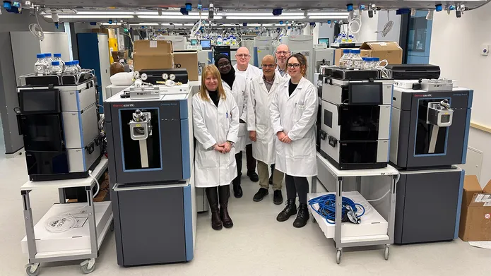Fingerprints Proteomics Facility team standing next to the two novel Orbitrap Astral Mass Spectrometers, which are now partially assembled.