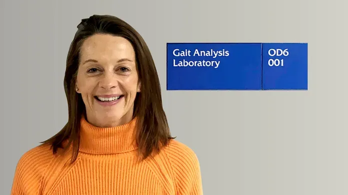 Jane Grant in front of lab sign