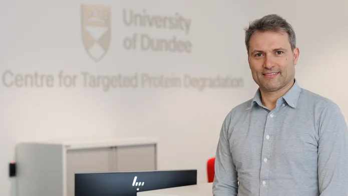 Professor Alessio Ciulli in from of a University of Dundee crest