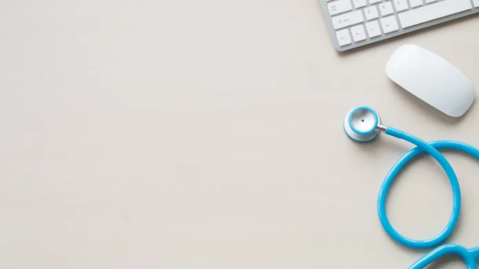 An aerial view of a desk with a stethoscope, mouse and keyboard on the right hand side