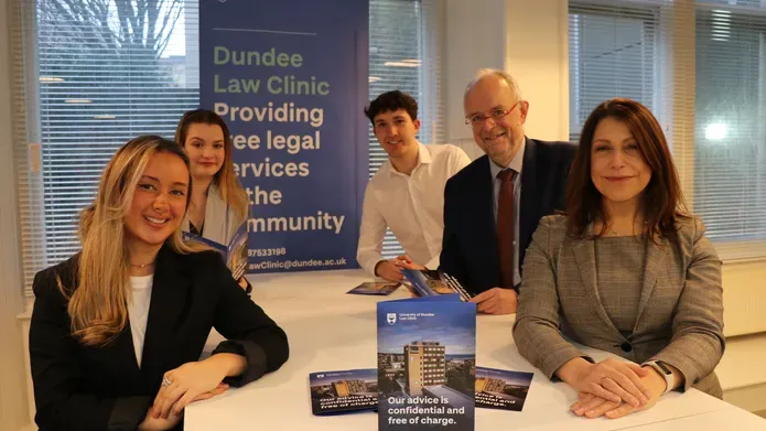 People standing around a white table with leaflets on it