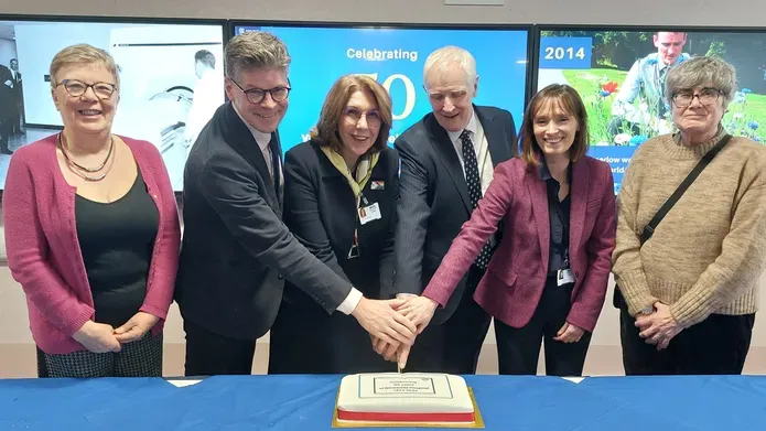 University and NHS Tayside executives cut a cake