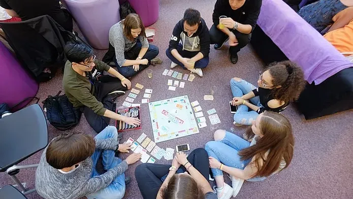 students sitting around a monopoly board
