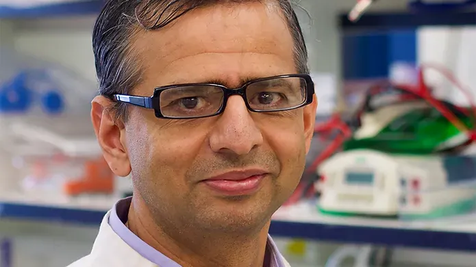 Profile photograph of Professor Gopal Sapkota wearing a lab coat in a lab setting