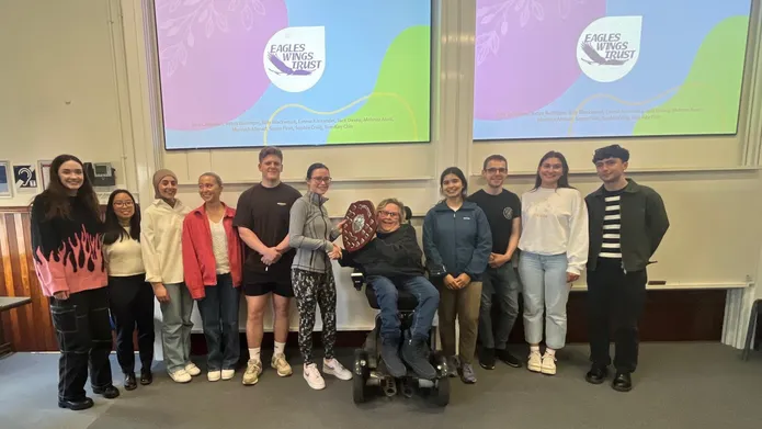 Students from the University of Dundee, stand in a line and collect a wooden shield, as recognition of their success in the Dental Public Health project.
