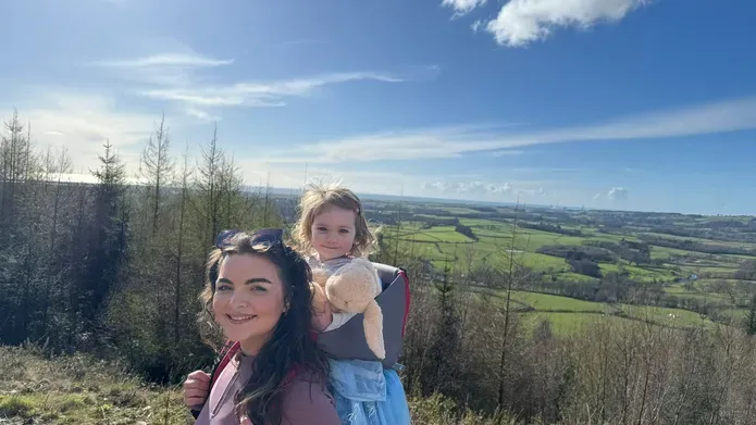 Nicole Hindley walking in the countryside with Skye on her back