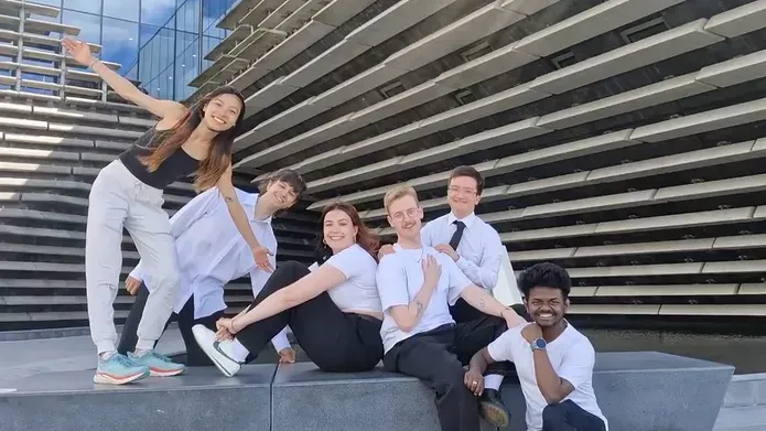 A group of six students on a bench outside of the V&A museum in Dundee.
